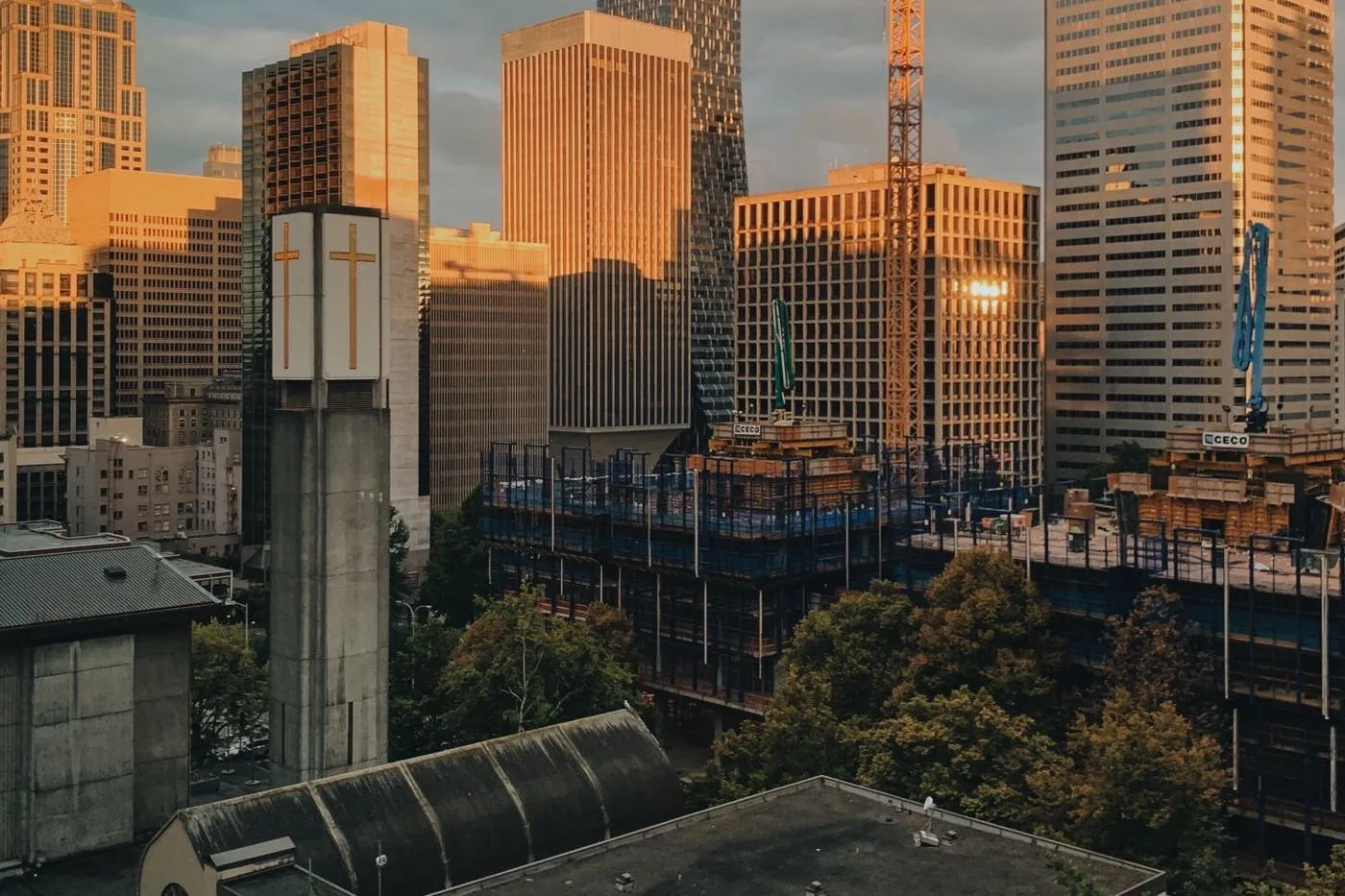 Seattle skyline with tower cranes over new construction at sunset