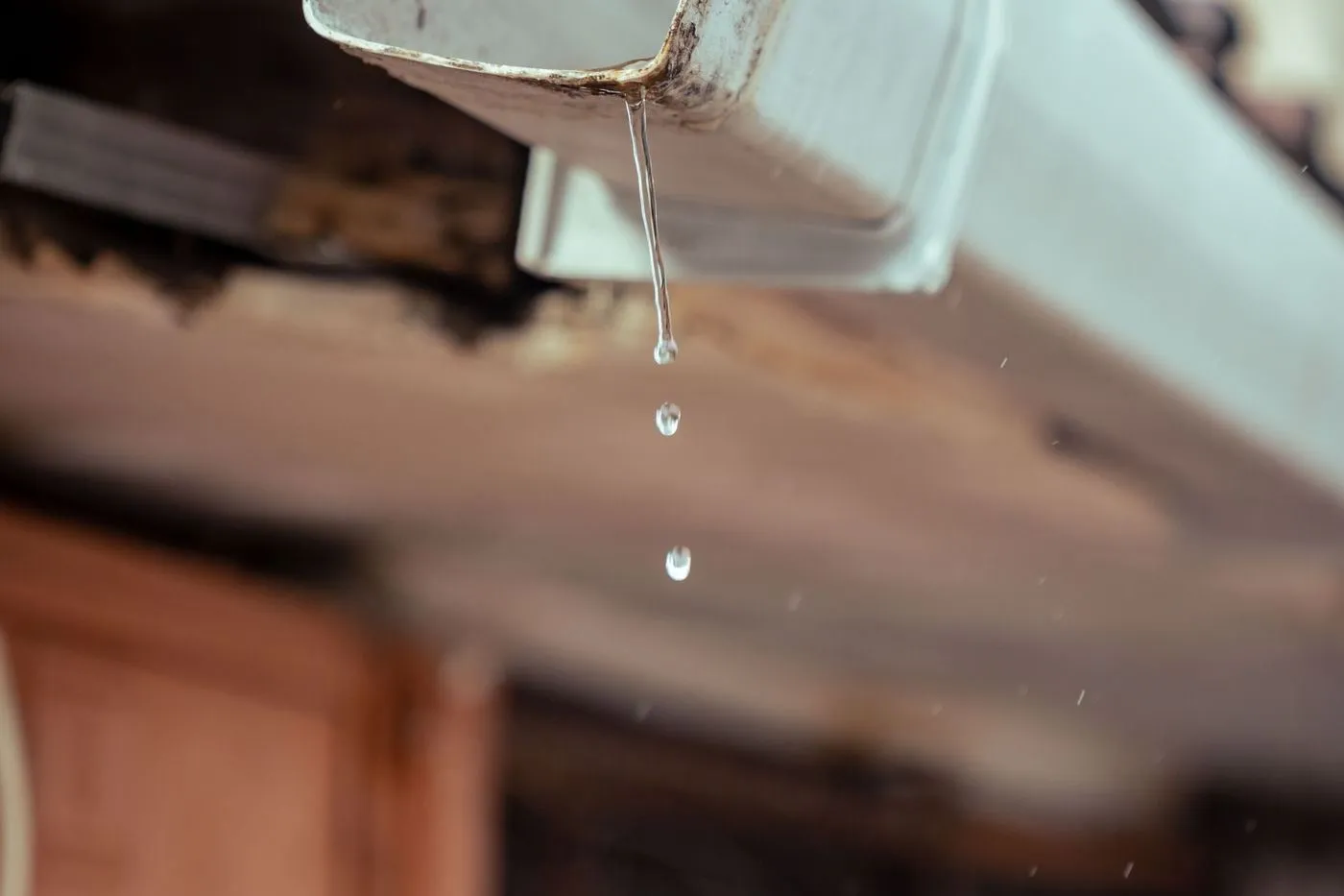 Rainwater dripping from a house gutter