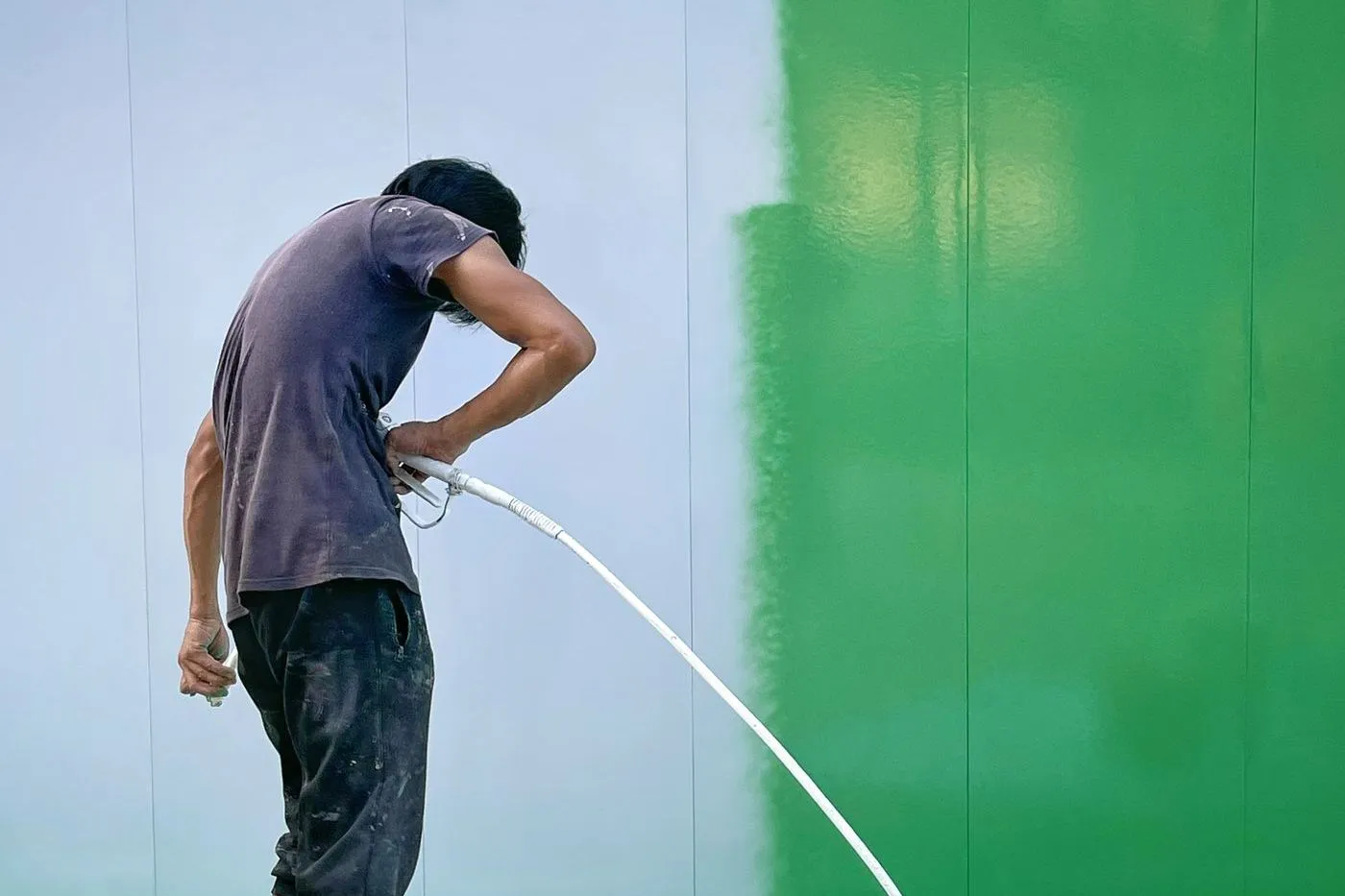 Painter spraying a large interior wall