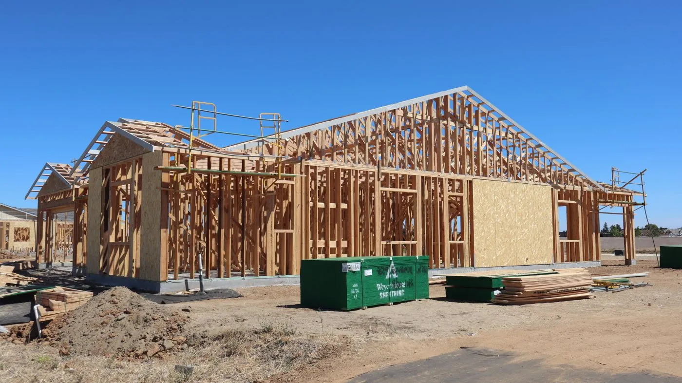 Wood-framed single-family home under construction with roof trusses in place