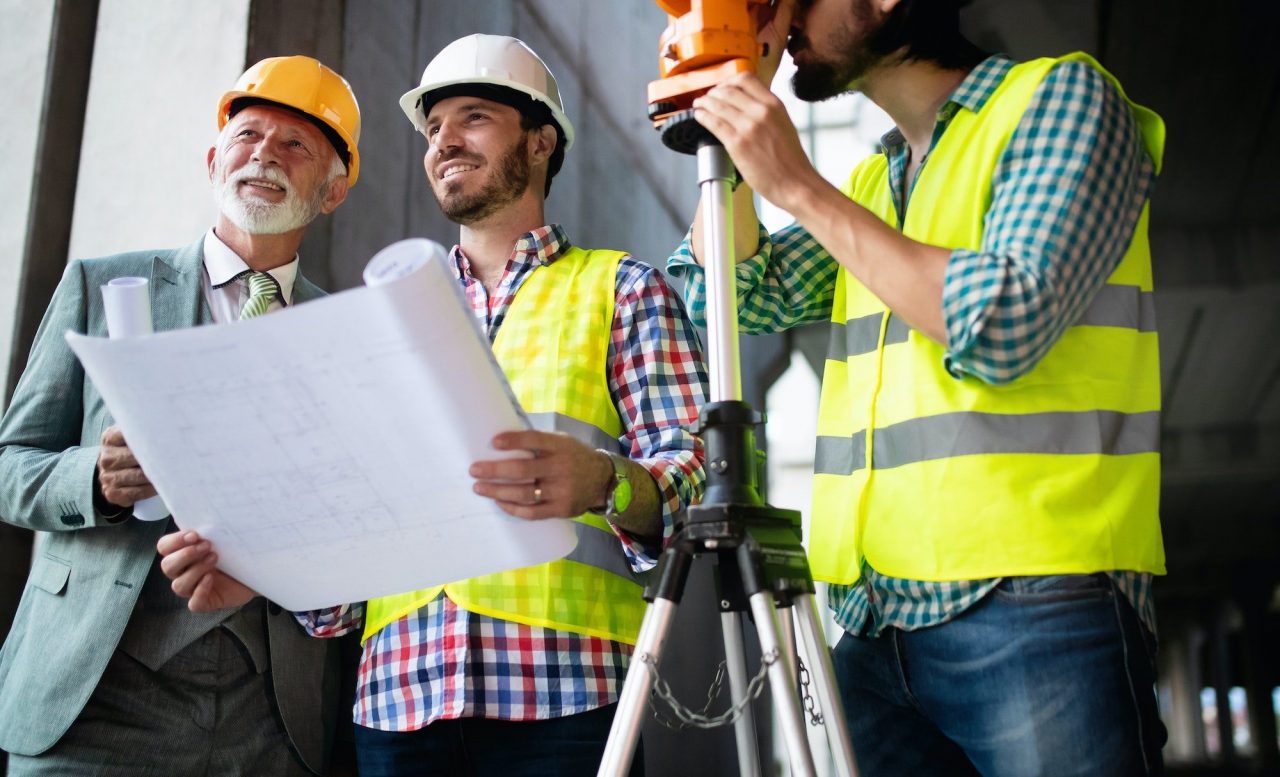 construction engineer with foreman worker checking construction site e1669905468418